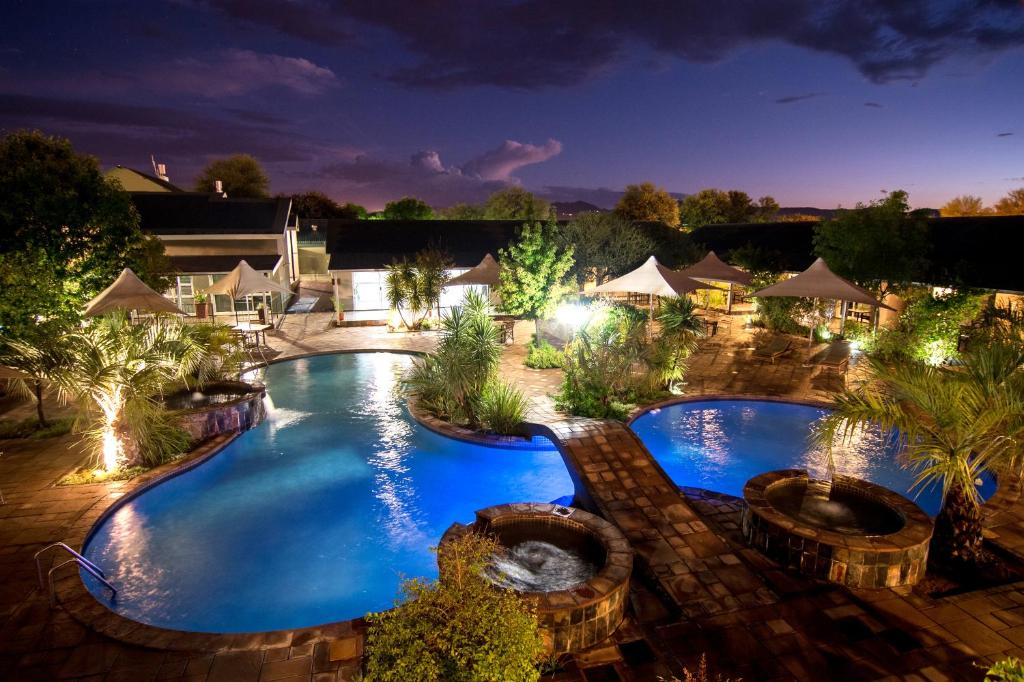 Arebbusch Travel Lodge, Windhoek: swimming pool at night