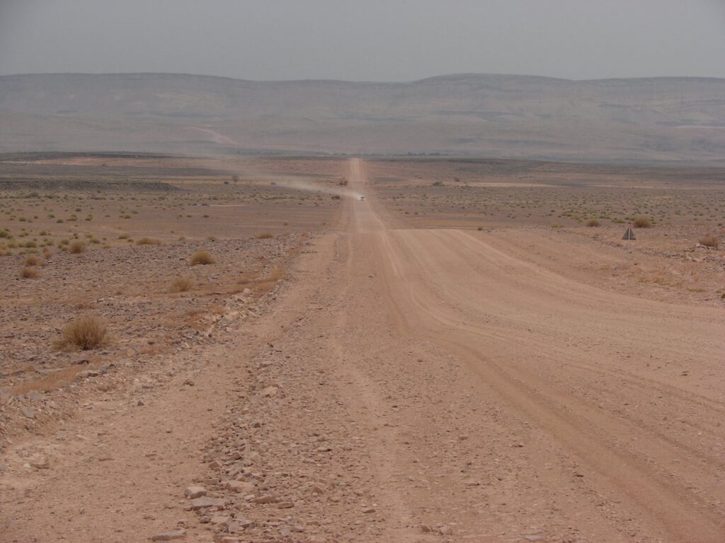 Long straight gravel road through southern Namibia, the kind of self-drive route packing preparation is aimed at