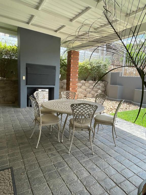 City Comfort Self Catering, Windhoek — patio with table, chairs and fireplace