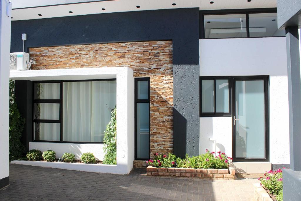 Deluxe Residence, Windhoek — brick house with black windows and flowers
