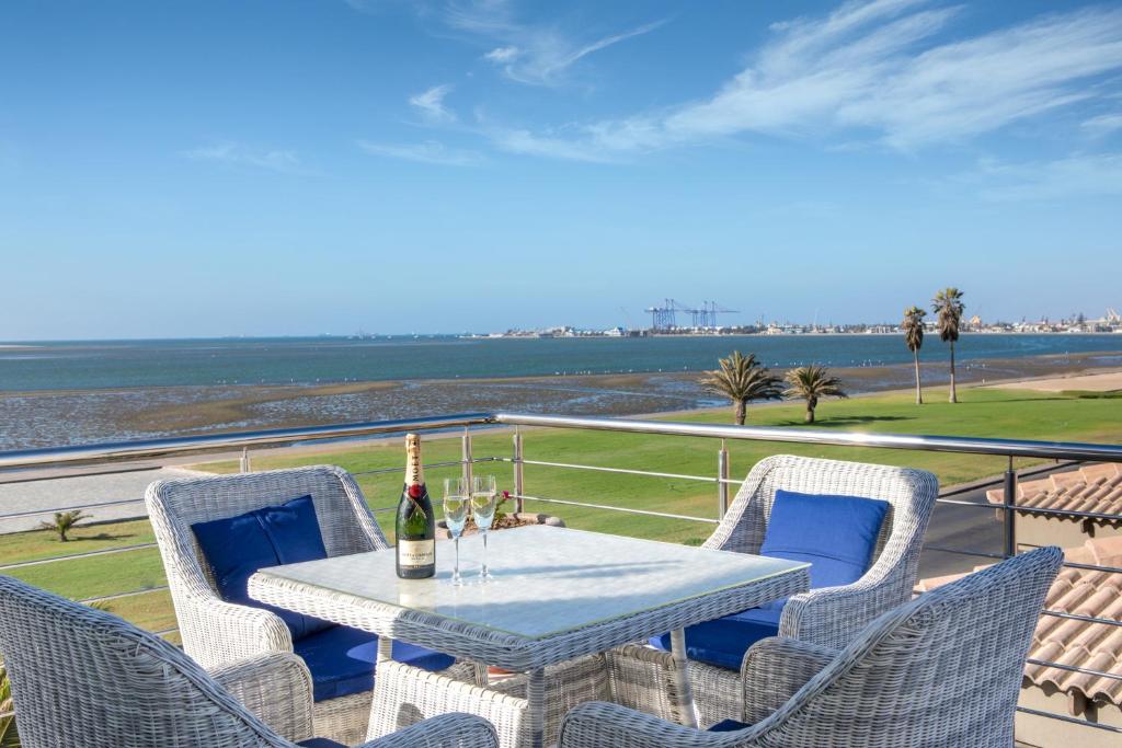 Flamingo Villas Boutique Hotel Walvis Bay: asientos en el balcón con vistas a la laguna