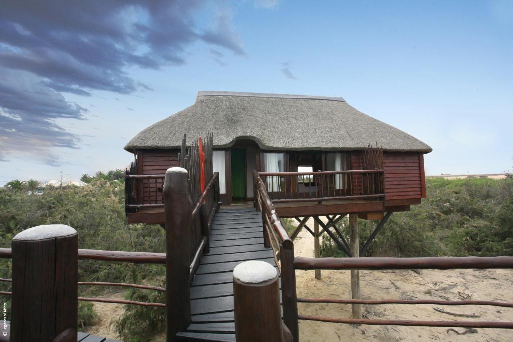 Stiltz Guest House, Swakopmund: stilted chalet and wooden walkway by the beach