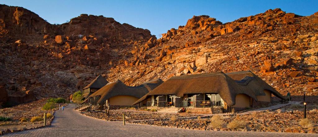 Twyfelfontein Country Lodge: el lodge frente a la pared rocosa