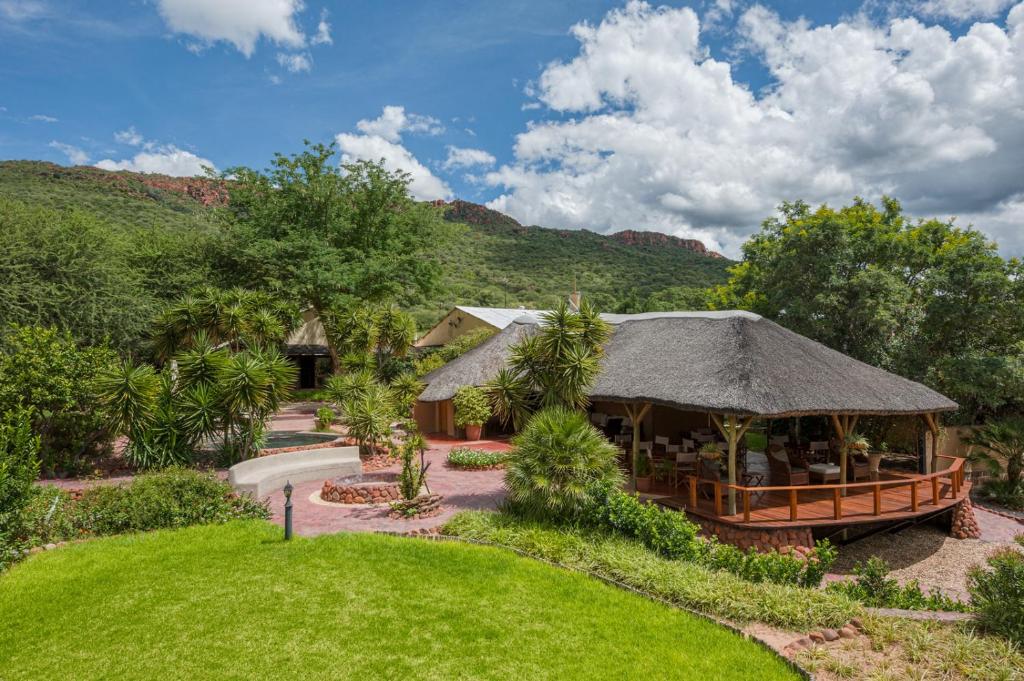 Waterberg Guest Farm: casa de la granja con techumbre de paja y jardín