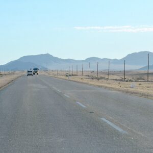 B2 road crossing an open Namibian landscape beneath the Rössing Mountains
